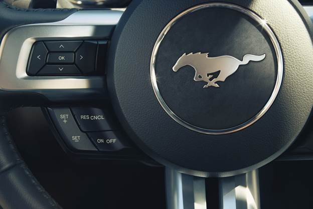 A beefy, stylish, three-spoke steering wheel carries all of the necessary Sync and cruise control buttons. It also wears one of the few running horse emblems seen on the '15 Mustang.